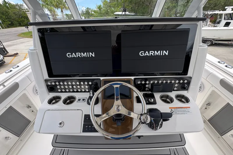 Slide: The Image of 2027 Caymas 401 DR boat dashboard with dual Garmin displays and modern controls. - 41