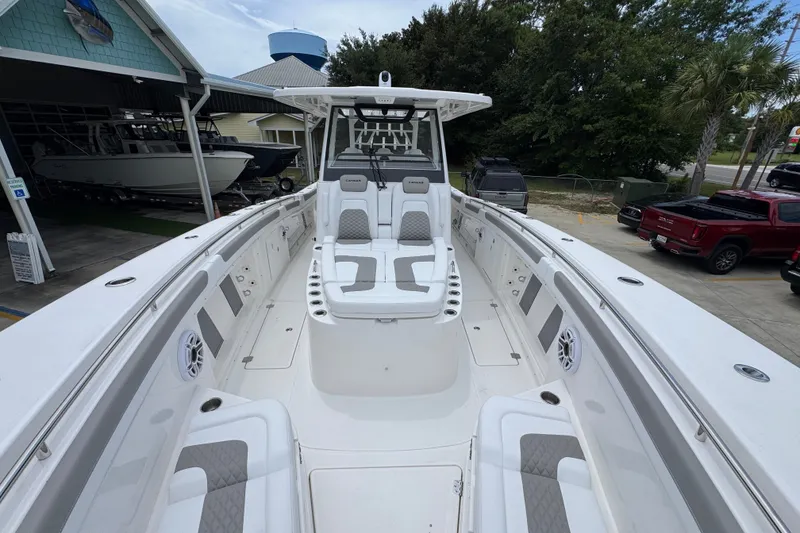 Slide: The Image of 2027 Caymas 401 DR boat with spacious seating and modern design at a marina. - 25
