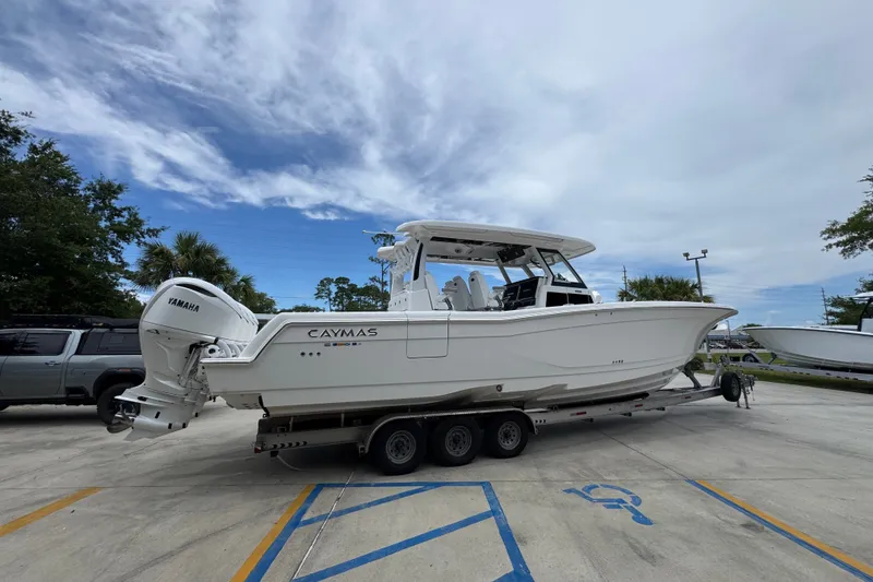 Slide: The Image of 2027 Caymas 401 DR boat on trailer, featuring Yamaha engines, parked outdoors. - 14