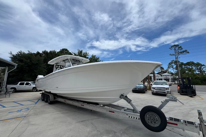Slide: The Image of 2027 Caymas 401 DR boat on trailer in parking lot under cloudy sky. - 9