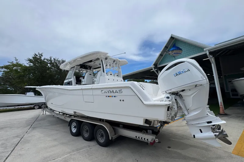 Slide: The Image of 2027 Caymas 401 DR boat with Yamaha engine on trailer, parked outdoors. - 19