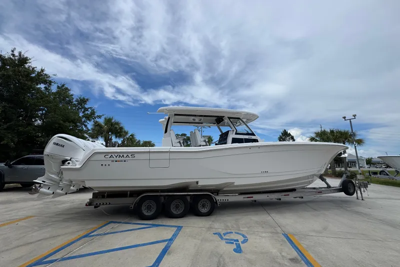 Slide: The Image of 2027 Caymas 401 DR boat on trailer, featuring sleek design and Yamaha engines. - 13