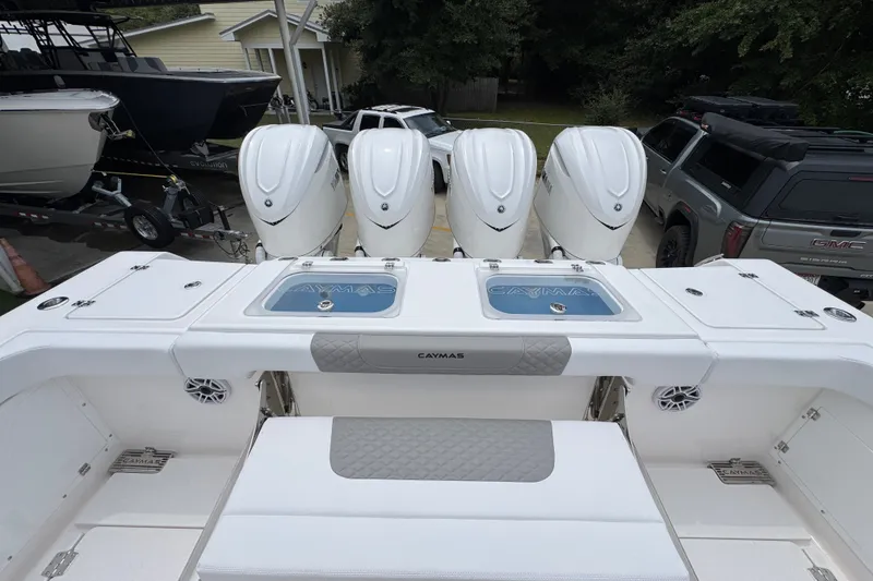 Slide: The Image of 2027 Caymas 401 DR boat with four powerful outboard engines, parked near other vehicles. - 53