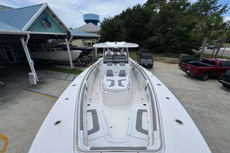 Slide: The Image of 2027 Caymas 401 DR boat with spacious deck and seating, parked at a marina. - 24