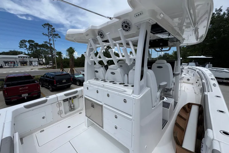 Slide: The Image of 2027 Caymas 401 DR boat interior with seating and storage, parked outdoors. - 49