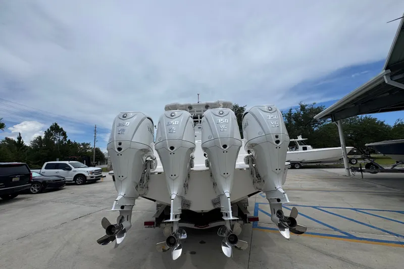Slide: The Image of 2027 Caymas 401 DR boat with four powerful outboard engines in a parking area. - 17