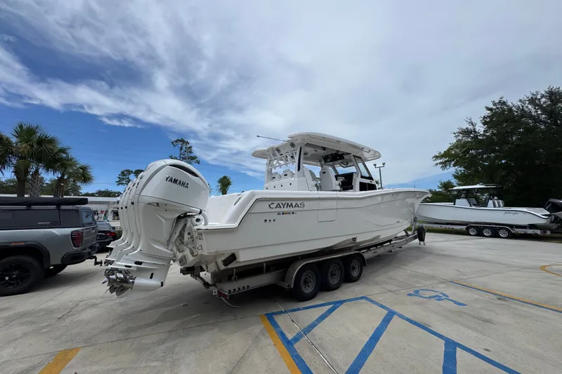Slide: The Image of 2027 Caymas 401 DR boat on trailer with Yamaha engines, parked outdoors. - 15