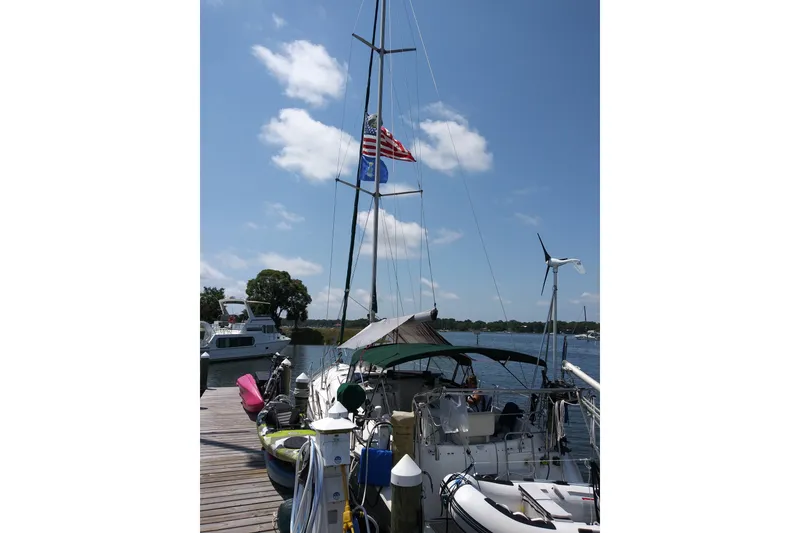 Slide: The Image of Beneteau Oceanis 411 Celebration yacht docked, flags flying, clear sky, 1999 model. - 16