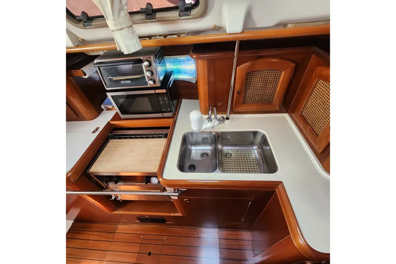 Slide: The Image of Galley kitchen in 1999 Beneteau Oceanis 411 Celebration yacht with wood cabinetry and appliances. - 26