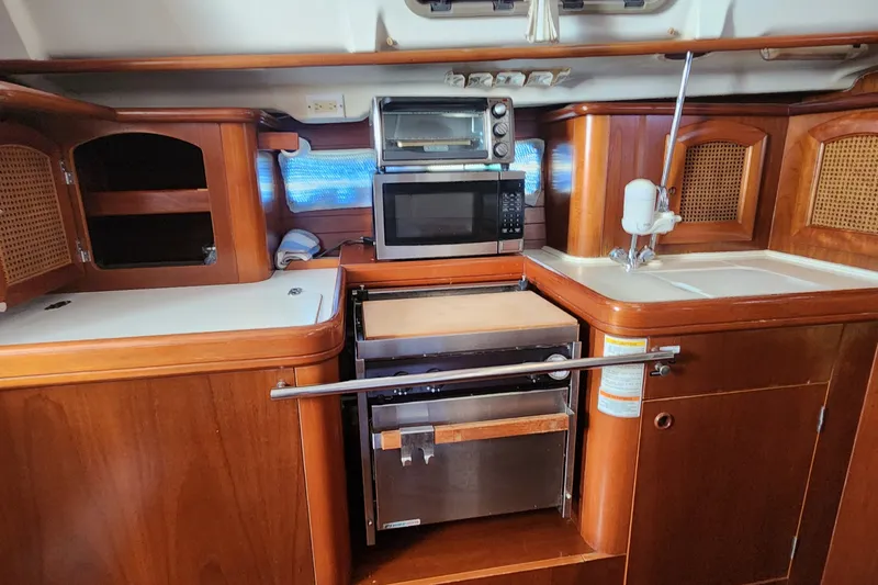 Slide: The Image of Interior of 1999 Beneteau Oceanis 411 Celebration yacht kitchen with wood cabinetry and appliances. - 24