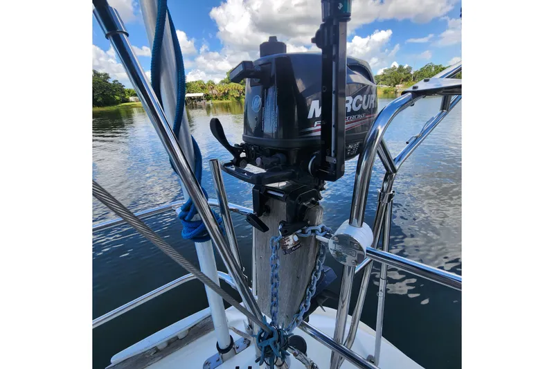 Slide: The Image of Outboard motor on 1999 Beneteau Oceanis 411 Celebration sailboat, docked on a serene lake. - 42