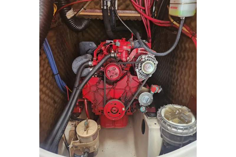 Slide: The Image of Engine compartment of 1999 Beneteau Oceanis 411 Celebration sailboat, featuring red engine components. - 37