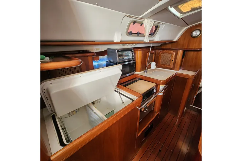 Slide: The Image of Interior of 1999 Beneteau Oceanis 411 Celebration yacht kitchen with wood finish and appliances. - 27