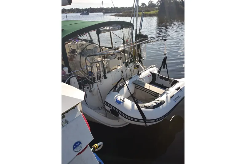 Slide: The Image of Beneteau Oceanis 411 Celebration yacht with dinghy, 1999 model, docked on calm water. - 15