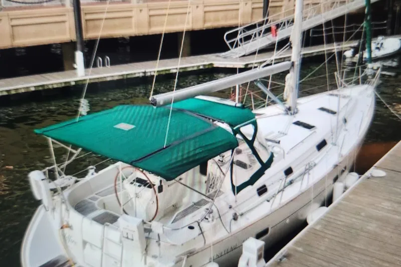 Slide: The Image of (sister ship) 1999 Beneteau Oceanis 411 Celebration sailboat docked with green canopy. - 3