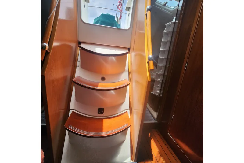 Slide: The Image of Interior stairs of a 1999 Beneteau Oceanis 411 Celebration yacht, featuring wooden steps. - 17