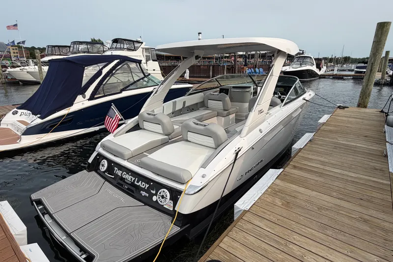 Slide: The Image of 2024 Regal LS9 boat docked at marina, featuring sleek design and spacious seating. - 3