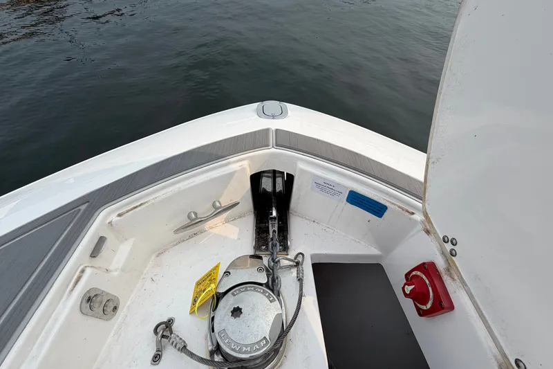 Slide: The Image of 2024 Regal LS9 boat anchor compartment with winch, open hatch, and water view. - 35