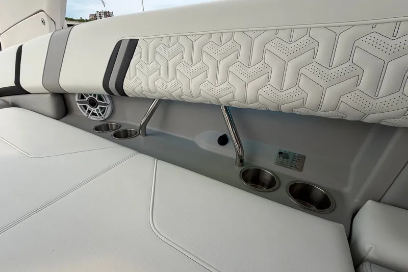 Slide: The Image of 2024 Regal LS9 boat interior with stylish upholstery, cup holders, and speaker detail. - 14