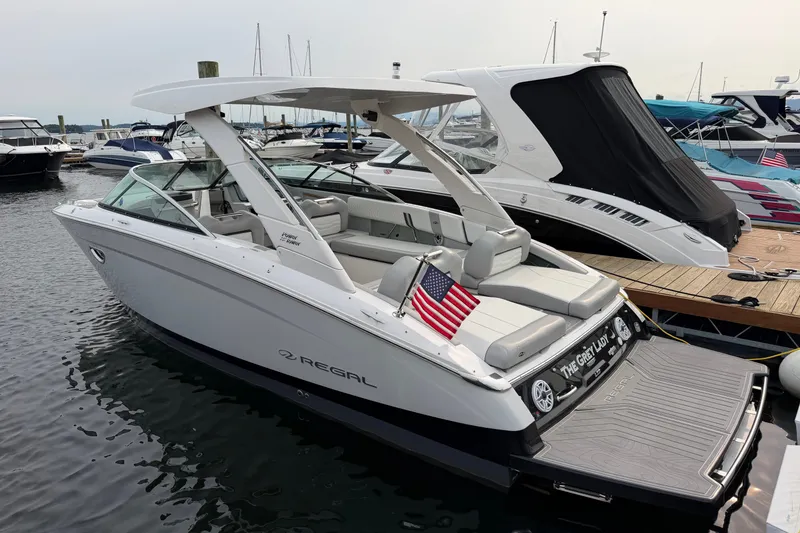 Slide: The Image of 2024 Regal LS9 boat docked, featuring sleek design and American flag. - 1