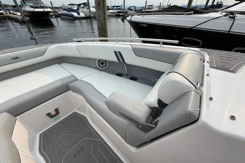 Slide: The Image of 2024 Regal LS9 boat interior with sleek seating and modern design at a marina. - 34