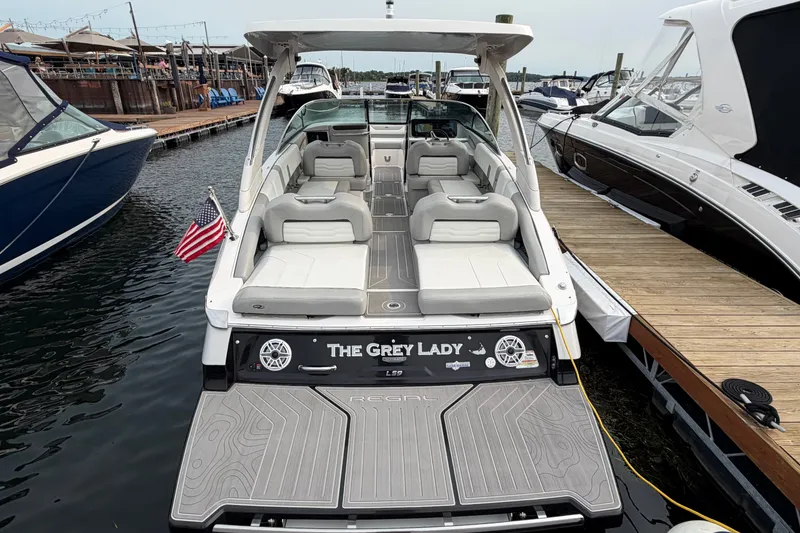 Slide: The Image of 2024 Regal LS9 boat docked, featuring spacious seating and sleek design. - 2