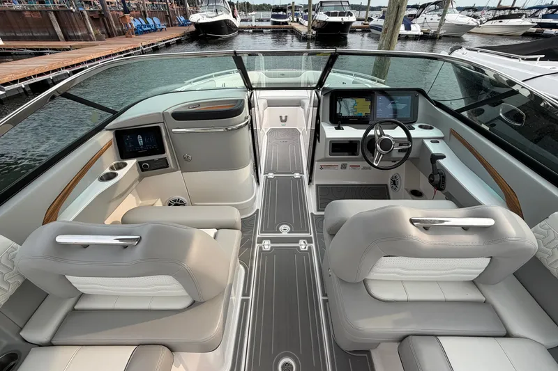 Slide: The Image of Luxurious 2024 Regal LS9 boat interior with modern dashboard and comfortable seating at a marina. - 18