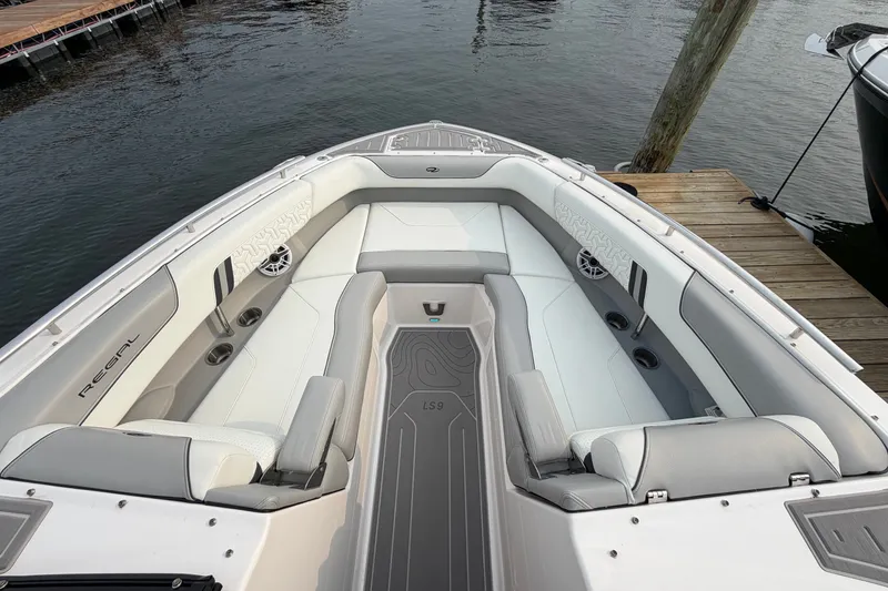 Slide: The Image of 2024 Regal LS9 boat interior with luxurious seating and modern design at a dock. - 32