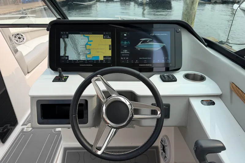 Slide: The Image of 2024 Regal LS9 boat dashboard with steering wheel and dual navigation screens. - 21