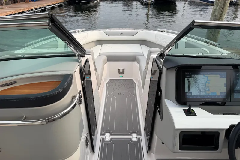 Slide: The Image of 2024 Regal LS9 boat interior with modern dashboard and seating, dockside view. - 30