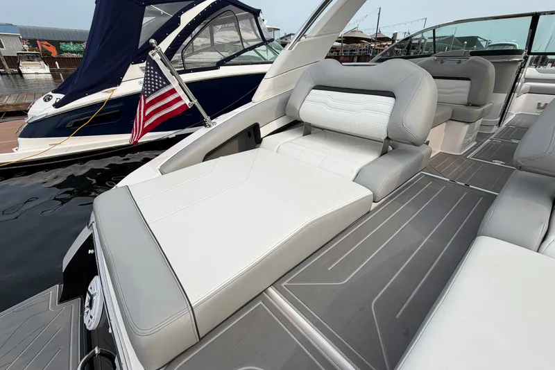 Slide: The Image of 2024 Regal LS9 boat interior with luxurious seating and American flag, docked at marina. - 8
