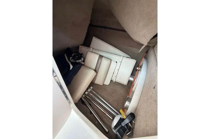 Slide: The Image of 2007 Chaparral 256 SSi boat interior storage with folded seats and metal poles. - 19