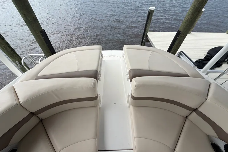 Slide: The Image of 2007 Chaparral 256 SSi boat interior with beige seating, docked by the water. - 14