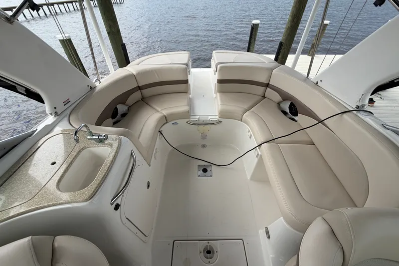 Slide: The Image of 2007 Chaparral 256 SSi boat interior with beige seating and sink, docked by water. - 13