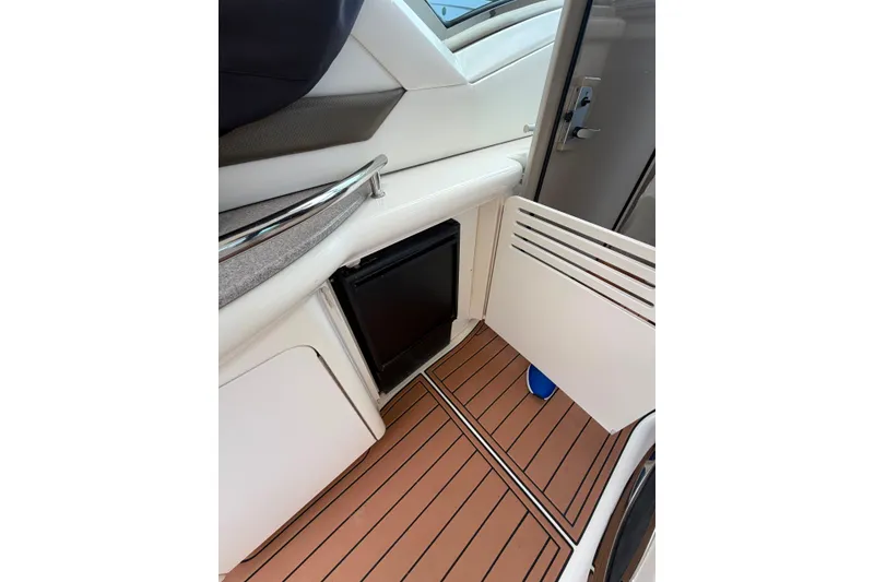 Slide: The Image of 2006 Sea Ray 40 Sundancer interior with teak flooring and compact fridge. - 15