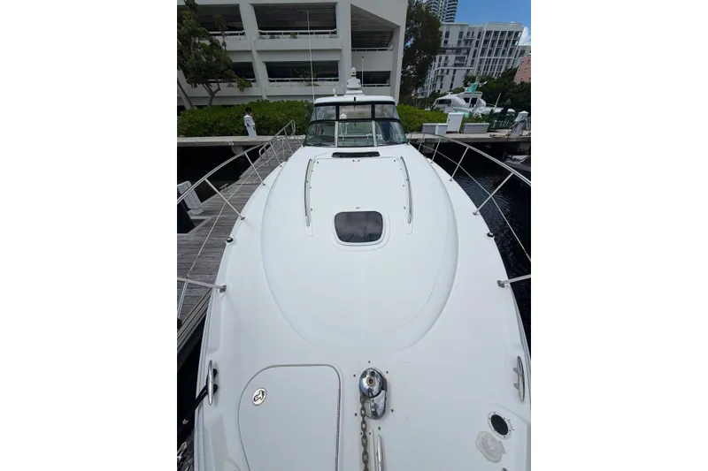 Slide: The Image of 2006 Sea Ray 40 Sundancer yacht docked, showcasing sleek white deck and modern design. - 18