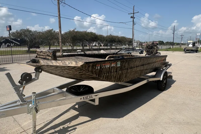 Slide: The Image of 2026 Excel 1751 Shallow Water F4 boat on trailer, camo design, parked outdoors. - 9