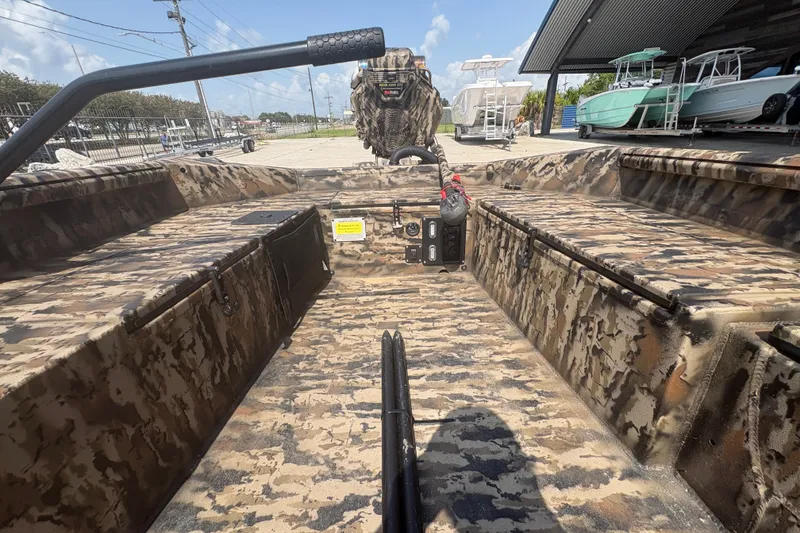 Slide: The Image of 2026 Excel 1751 Shallow Water F4 boat interior with camouflage design, parked outdoors. - 18