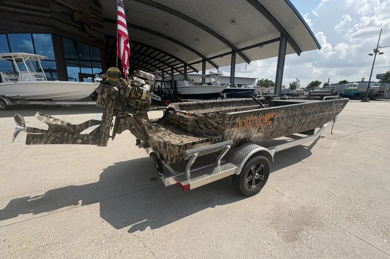 Slide: The Image of 2026 Excel 1751 Shallow Water F4 boat on trailer, camo design, parked outdoors. - 5
