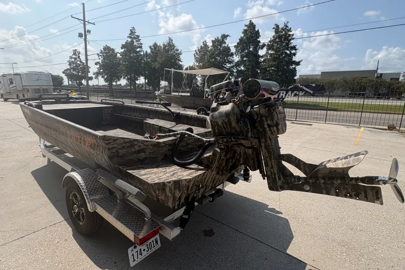 Slide: The Image of 2026 Excel 1751 Shallow Water F4 boat on trailer, camo design, outdoor setting. - 7