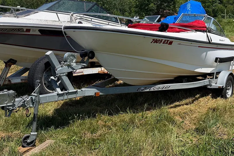 The Image of 1996 Boston Whaler 170 Dauntless boat on trailer, parked on grass. - 1
