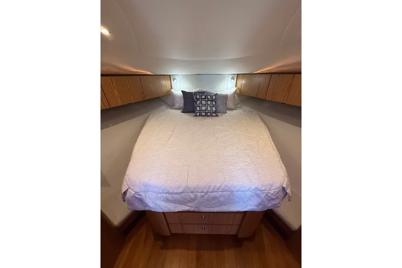 Slide: The Image of 2023 Tiara Yachts 4300 Open cabin interior with cozy bed and wooden cabinetry. - 25