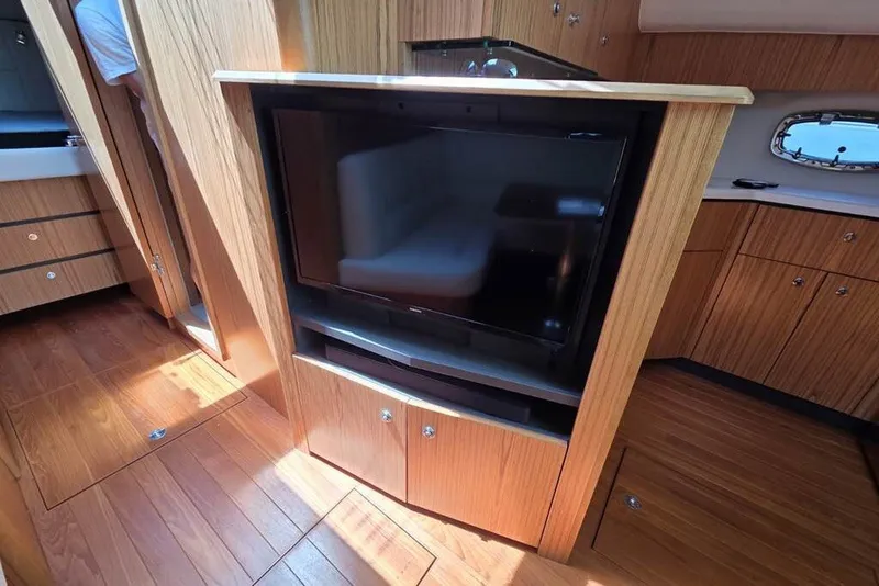 Slide: The Image of 2023 Tiara Yachts 4300 Open interior with wood cabinetry and built-in TV. - 20