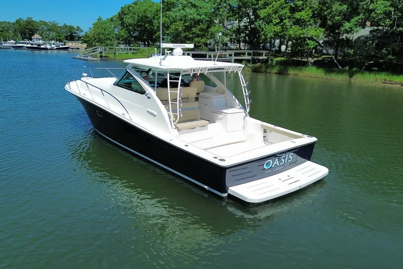 The Image of A 2023 Tiara Yachts 4300 Open cruising on a calm river. It features a sleek design with a spacious cockpit and swim platform. - 0