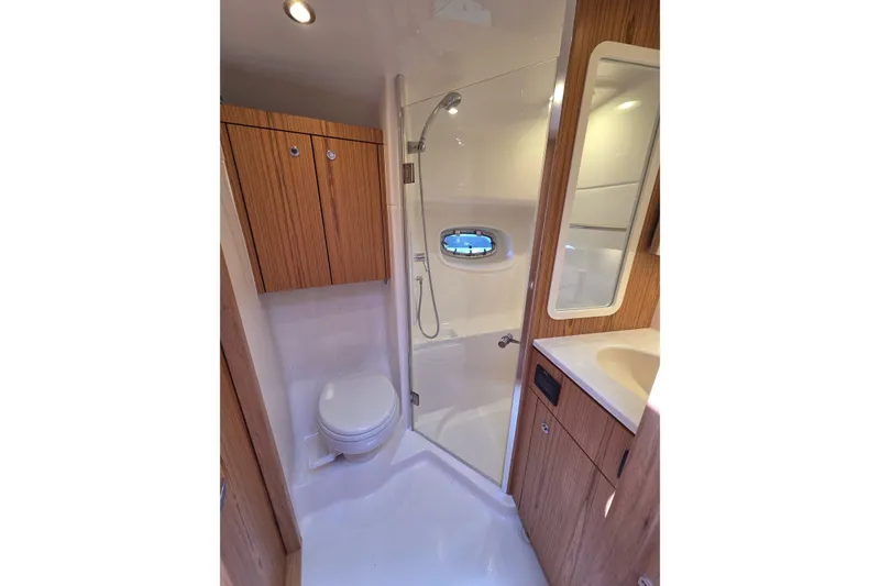 Slide: The Image of Luxurious bathroom in 2023 Tiara Yachts 4300 Open, featuring modern fixtures and wood accents. - 26