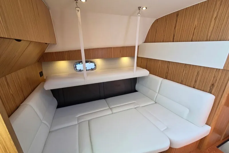 Slide: The Image of 2023 Tiara Yachts 4300 Open cabin interior with white seating and wood accents. - 23