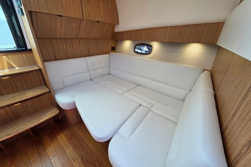 Slide: The Image of Luxurious interior of 2023 Tiara Yachts 4300 Open with white seating and wooden accents. - 22