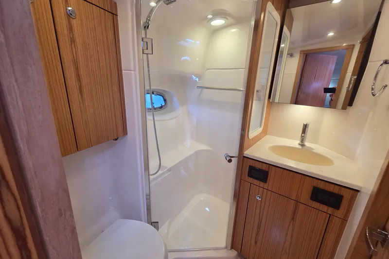 Slide: The Image of Luxurious bathroom in 2023 Tiara Yachts 4300 Open, featuring modern fixtures and wood accents. - 27