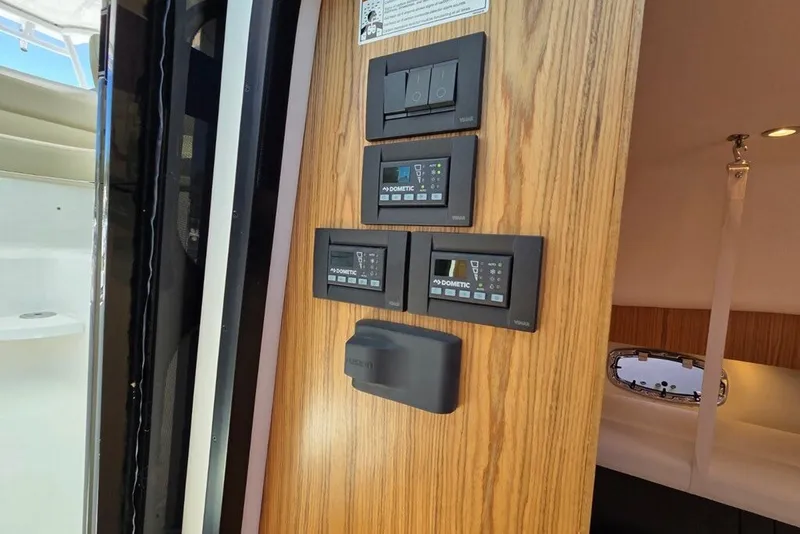 Slide: The Image of Control panel inside 2023 Tiara Yachts 4300 Open, featuring Dometic systems and modern wood finish. - 18
