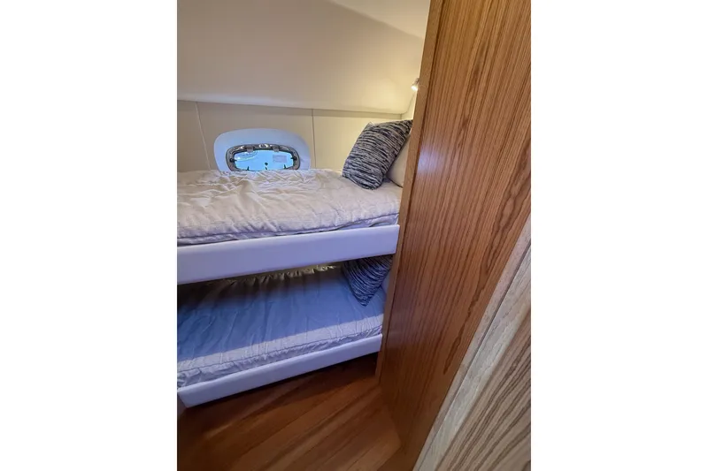 Slide: The Image of 2023 Tiara Yachts 4300 Open cabin with cozy bunk beds and wooden interior. - 29